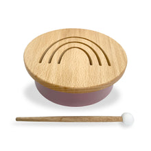 Load image into Gallery viewer, Solid beechwood drum with rainbow design cut into top. Base is a soft dusty rose color. Includes one beechwood mallet with a white head.