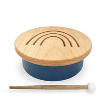 Load image into Gallery viewer, Solid beechwood drum with rainbow design cut into top. Base is a matte deep sea blue color. Includes one beechwood mallet with a white head.