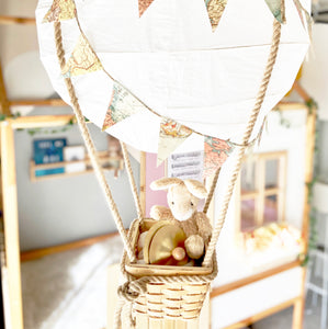 Baby brass cymbals held by plush bunny in hanging nursery hot air balloon 